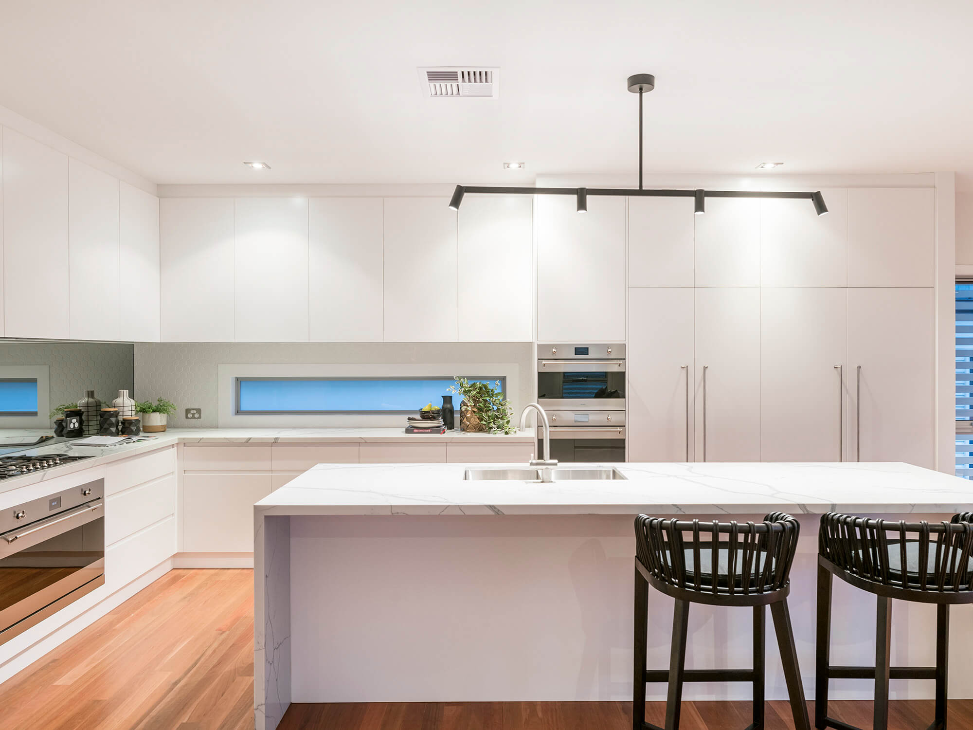 Modern white kitchen with marble benchtops after renovations